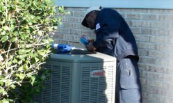 Image of technician performing check-up on outdoor fan