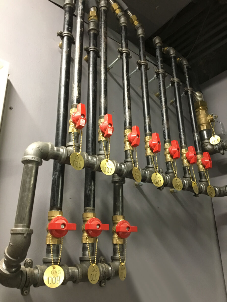 Pipes with red handles, and gold tags with specific numbers